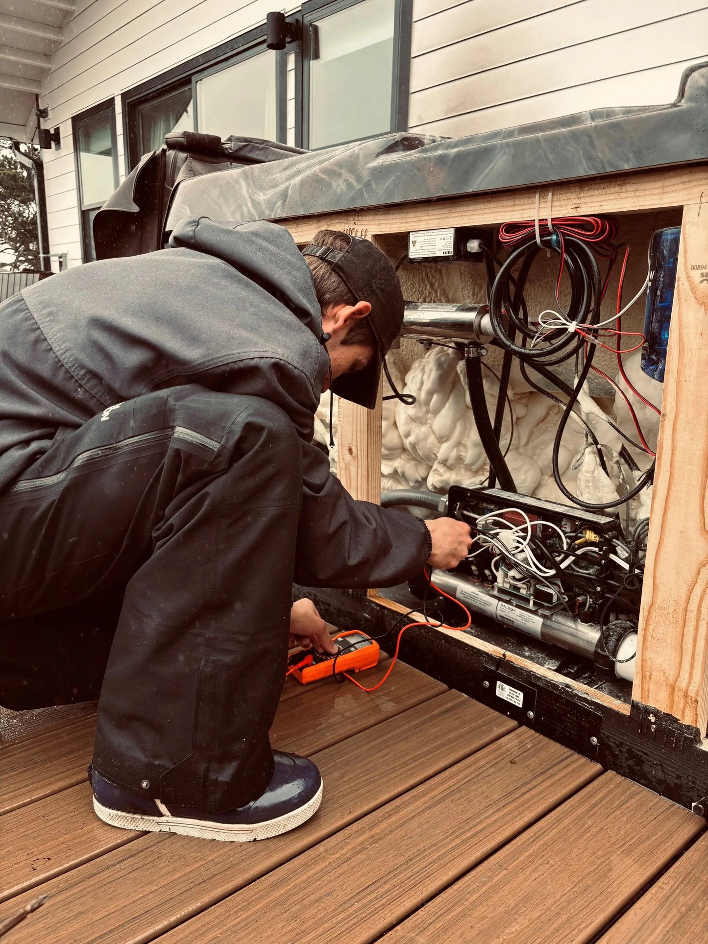 Person working on an Hot Tub, Diagnosing the problem on a wooden deck with a Multi meter